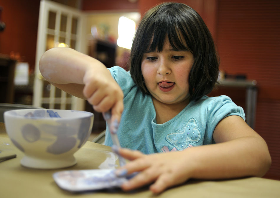 Olivia McAvoy, age 6, mixes her colors together as she decorates a bowl on Monday, Sept. 13, 2010, at Fired Up! in Peoria Heights. McAvoy was one of several YWCA child care kids who painted bowls on Monday to be sold for charity at Soup for the Shelter on Nov. 16. "We see this as kids helping kids since the average age of the homeless is nine," Sherry Killian, secretary of the YWCA board, said.