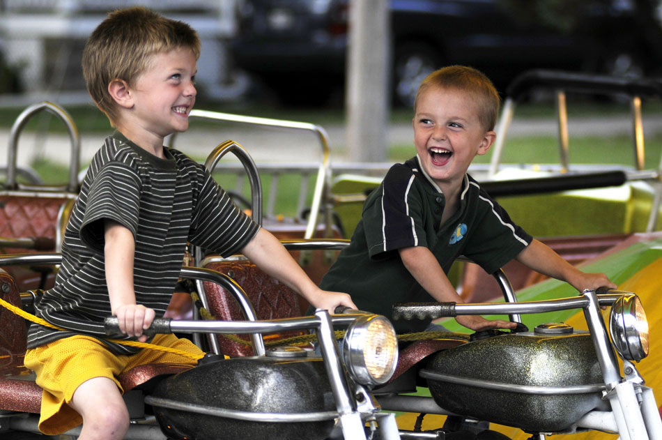 Brothers Matthew Williams, left, age 5, and Keaton Williams, age 3, share a few laughs as they ride motorcycles and honk the horns on a ride on Thursday, Sept. 9, 2010, at the Fall Festival in Elmwood, Ill.