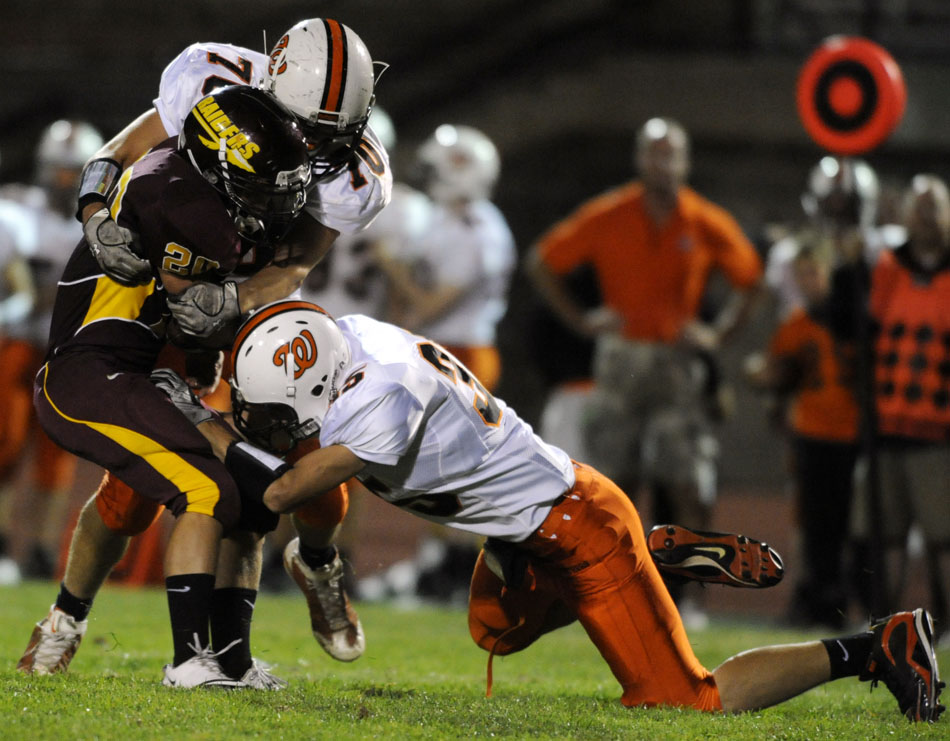 Washington's Brad Kuchenbecker (70) and Austin Harrell (35) bring down East Peoria's Cody Riley during a game on Friday, Sept. 10, 2010, in East Peoria.