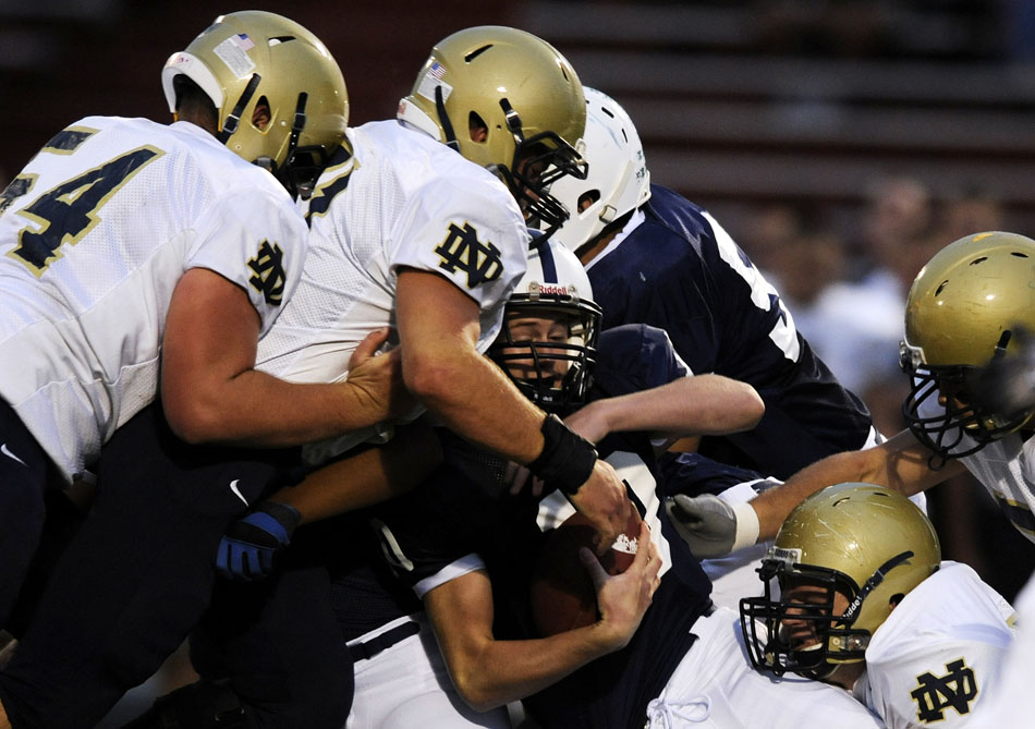 Peoria Notre Dame quarterback Guy Dillon, middle, is tackled by a group of Quincy Notre Dame defenders during a game on Thursday, Sept. 16, 2010, in Peoria.