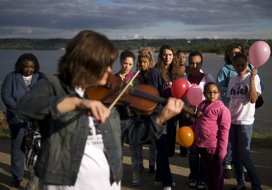 People watch as Jodi Smith plays the violin during a remembrance walk during the National Day of Remembrance on Sunday, Sept. 26, 2010, at the RiverPlex.