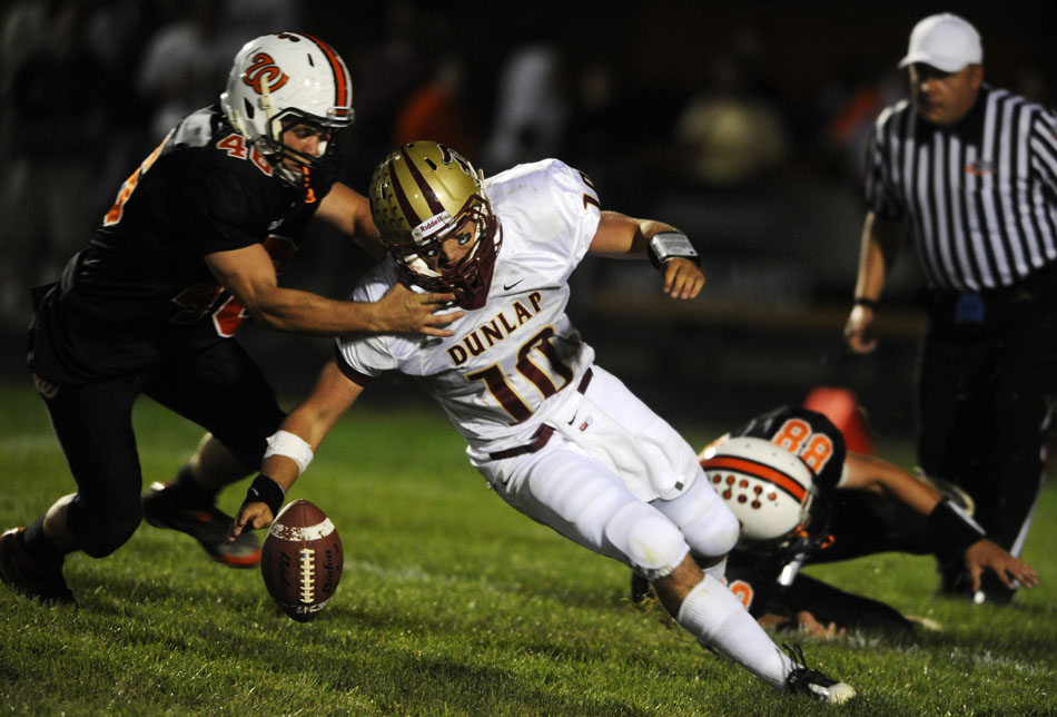 Dunlap quarterback Logan Schrader (10) tries to grab the football as it bounces away from him after being hit by Washington's Dan Massengill (46) and Zach Little (88) during a game on Friday, Sept. 17, 2010, in Washington.