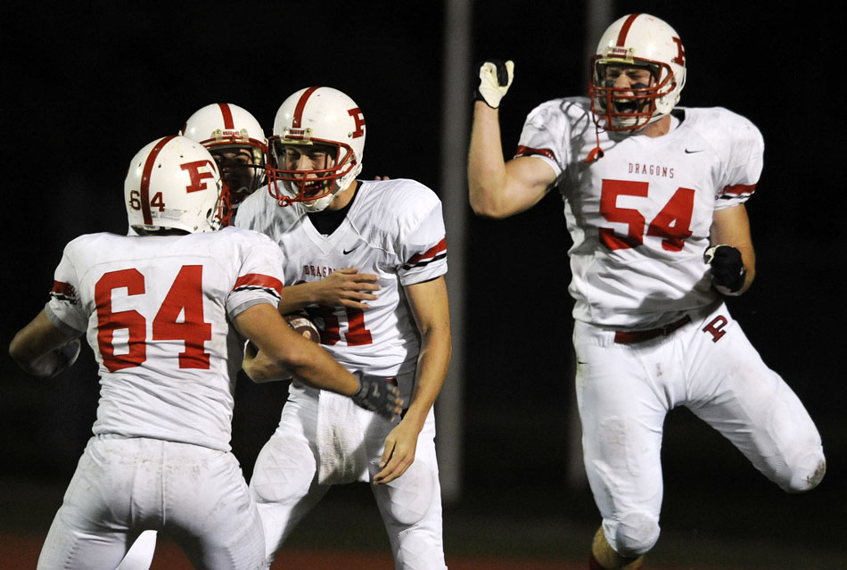 Pekin players celebrate with Cody Beal-Morris, middle, after he returned a blocked punt for a touchdown during the first half of a game against East Peoria on Friday, Oct. 15, 2010, in East Peoria.