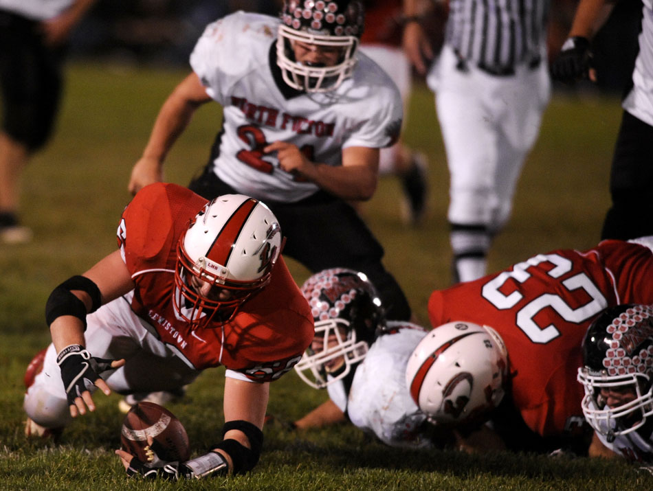 Lewistown defender Chris Henzler, left, dives away from a pile to secure  a fumble recovery during a game against North Fulton on Friday, Oct. 8, 2010, in Lewistown.
