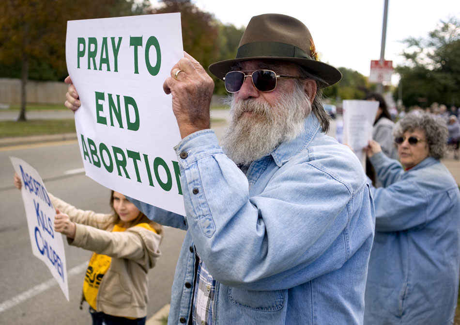 Ed Prechel, of Pekin, holds an anti-abortion sign along the southbound lane of University Street on Sunday, Oct. 3, 2010, in front of the St. Vincent De Paul School. Prechel was one of several people who held signs along University  Street as part of the Life Chain to protest abortion. This is the 20th year for the event, which is held on the first Sunday in October every year.