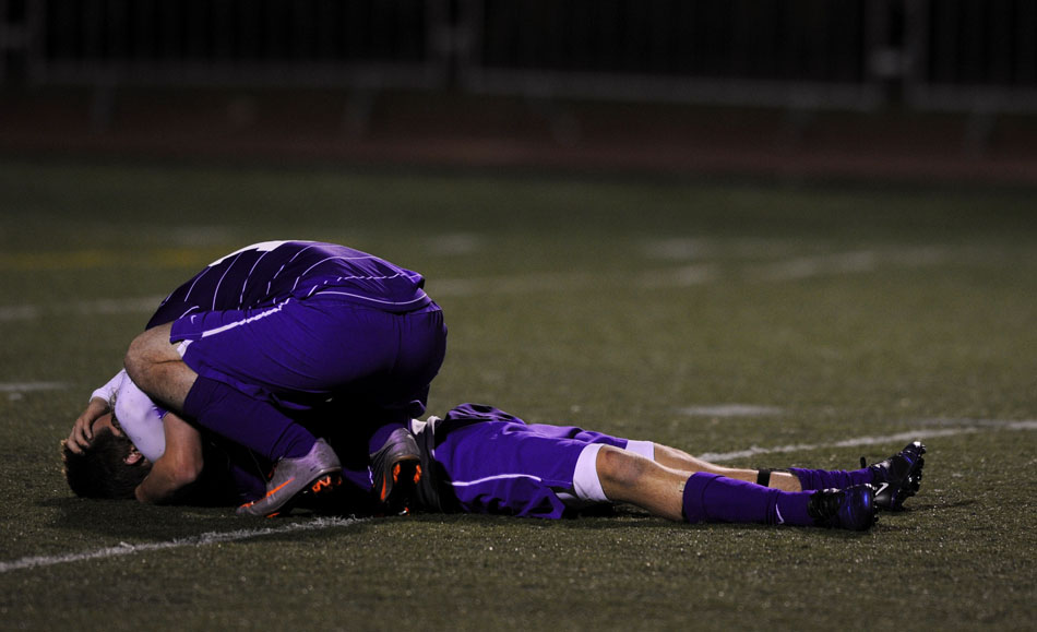 Peoria Christian senior Jordan Hawkins bends down to comfort teammate Jonathan Lehman (9) after the final buzzer in a 1-0 loss to Lisle in the state championship game on Saturday, Oct. 30, 2010, in Naperville.