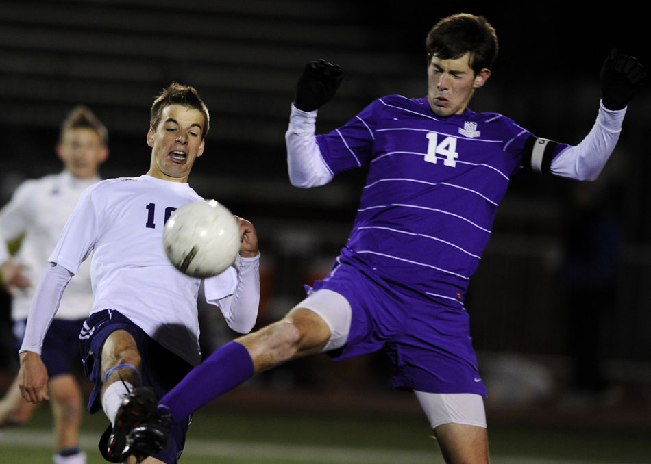 Lisle's Grant Fitzgerald, left, kicks the ball away from Peoria Christian senior Reese White (14) during the Class 1A state championship on Saturday, Oct. 30, 2010, in Naperville. Lisle won 1-0.