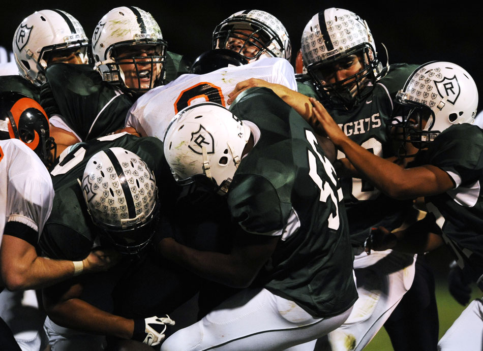 Richwoods defenders drag down Manual's Anthony Hollaway during the first half of a game on Friday, Oct. 1, 2010, at Richwoods High School.