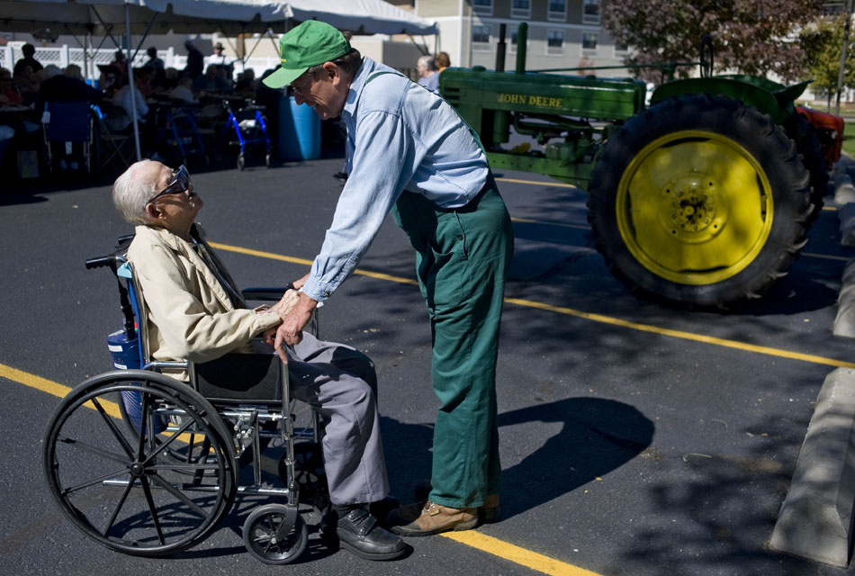 Terry Beachler, right, bends down to talk about his 1941 John Deere Model B tractor with Al Foster during an event on Thursday, Oct. 7, 2010, at Lutheran Hillside Village. Foster told Beachler he remembered the days when tractors had steel wheels without rubber tires.