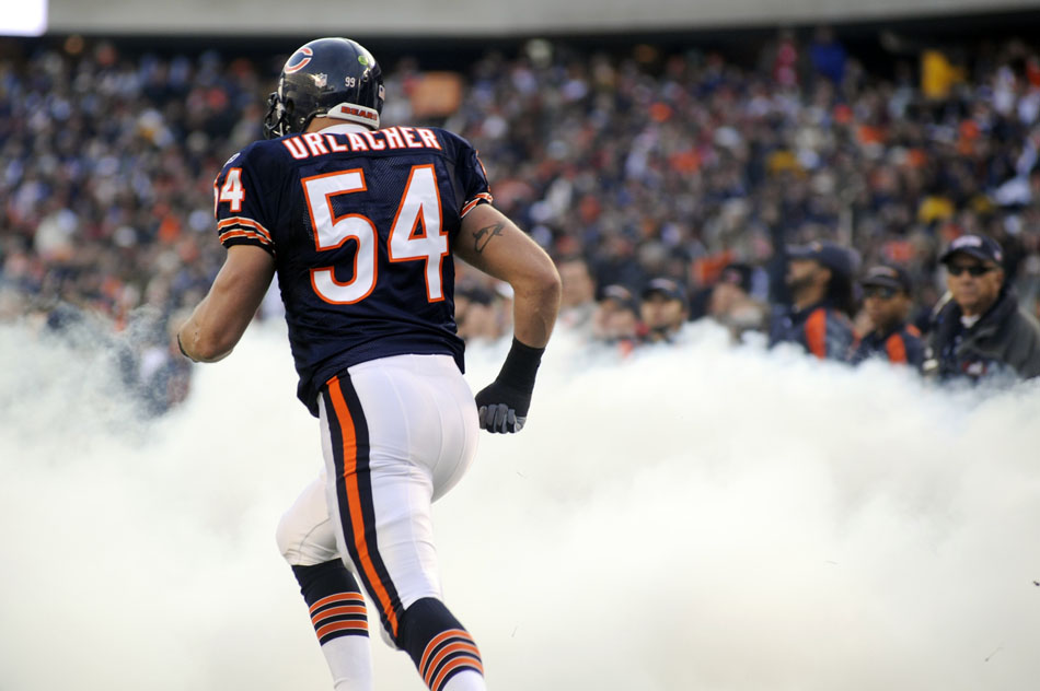Chicago Bears linebacker Brian Urlacher (54) runs onto the field through smoke during player introductions before a game on Sunday, Nov. 28, 2010, at Soldier Field in Chicago.