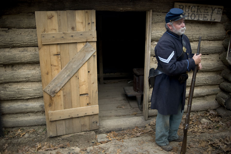 Russell Gibbs talks to visitors outside a makeshift cabin constructed to show  examples of Civil War winter encampments on Saturday, Nov. 20, 2010, at Sommer Park. The re-enactors, from the Central Illinois Living Historians, created the encampment to show visitors how soldiers lived during the winter months in the war.