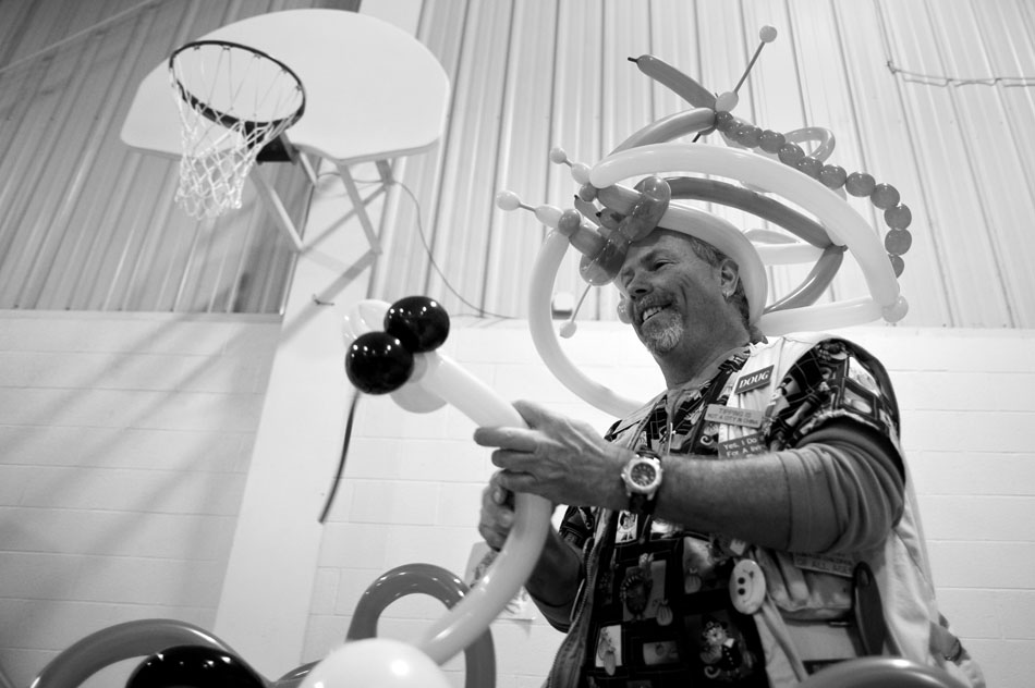 Balloon artist Doug Smith creates an animal for a youngster as volunteers cook, package and distribute Thanksgiving meals for the needy on Thursday, Nov. 25, 2010, at the South Side Mission.