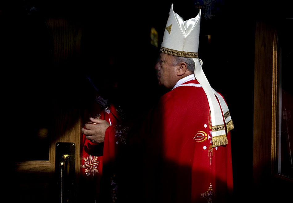 JAMES BROSHER/Journal Star The Rev. Faouzi Elia waits as an assistant sets up his wireless microphone at the back of the church before a Lebanese Mass on Sunday, Nov. 14, 2010, at St. Sharbel Church.