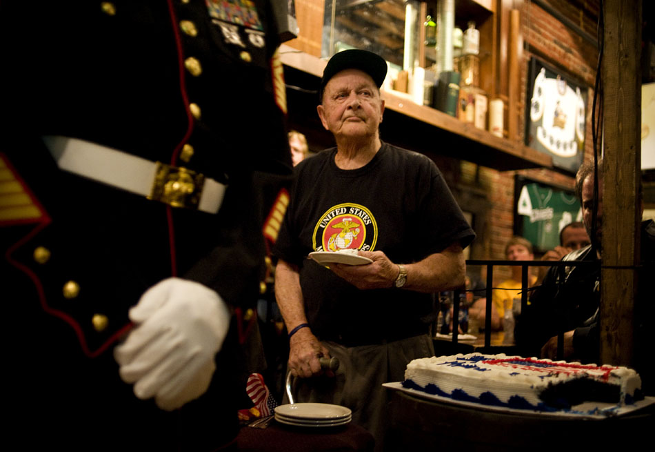 Karl Schmidt, a World War II veteran and Marine who served in the Battle of Iwo Jima in 1945, holds a piece of cake as one of the oldest Marines in attendance at a Semper Fi Fish Fry on Sunday, Nov. 7, 2010, at Kelleher's Irish Pub. The event featured a formal Marine cake cutting ceremony in which guests of honor, the oldest Marine and youngest Marine receive pieces of cake cut by a Mameluke sword.