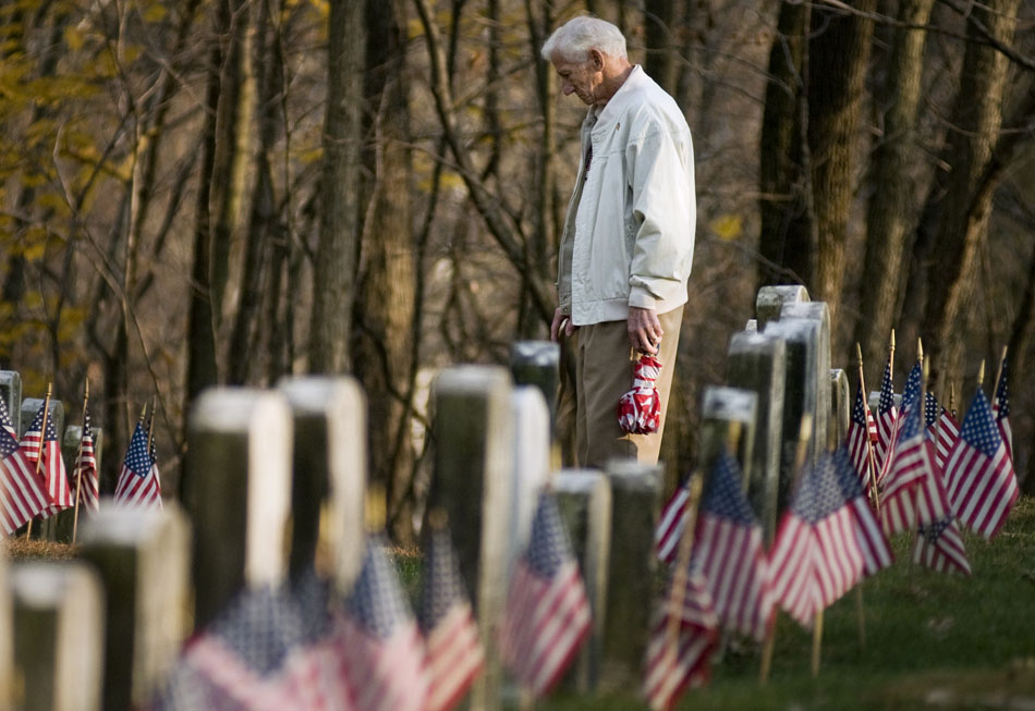 Joe Crandell, a veteran of the Marine reserves, pays his respects to a childhood friend, James Graham, who died serving in Korea, after a ceremony honoring Veterans Day on Thursday, Nov. 11, 2010, at Soldier's Hill in Springdale Cemetery. This year's ceremony paid special respects to veterans who died in the Korean conflict.