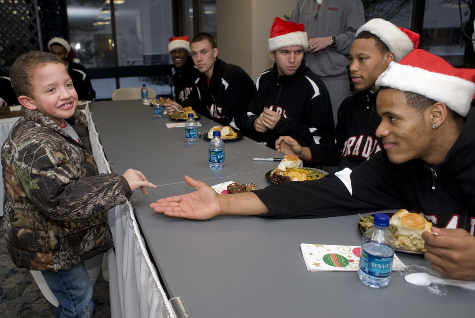 Payton McSimov, age 10, gives a high five to Bradley basketball guard Walt Lemon Jr. during Methodist  Hospital's annual Christmas dinner on Thursday, Dec. 16, 2010, at the hospital. The players greeted patients at Methodist and signed autographs.