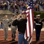 Terry Hicks, of Galsburg, Ill., salutes as taps are played to honor former East Peoria High School students who have been killed in the military during patriotic night ceremonies before a East Peoria-Washington football game on Friday, Sept. 10, 2010, in East Peoria. Hicks served with the Army in Vietnam.