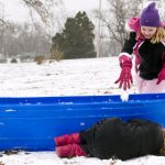 Despite her best effort to hide behind her sled, Chloe McCabe, age 9, still gets pummeled by a snow ball from Evie Fornoff, age 8, during a winter break camp for kids out of school for the holidays on Tuesday, Dec. 21, 2010, in Pekin, Ill. Temperatures in the mid 30s made for ideal sledding, snow ball fighting and snowman building conditions for the youngsters.