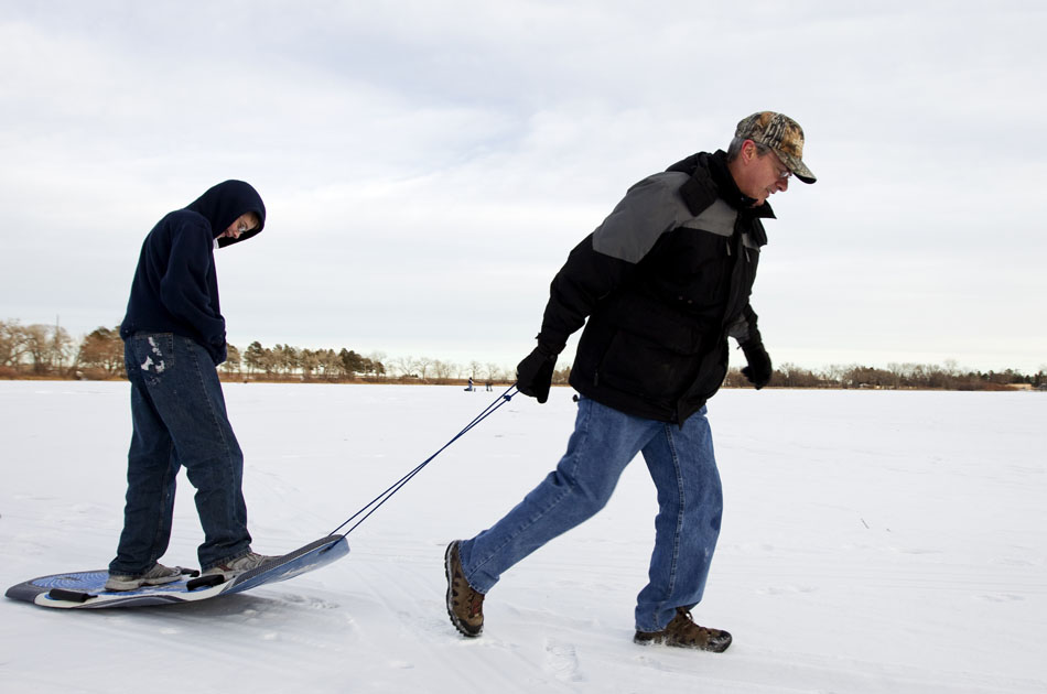 David Norby, right, pulls his son, Cameron, across a frozen Sloan Lake on Wednesday, Jan. 12, 2011, in Cheyenne. Despite temperatures in the high 30s Wednesday, several people made their way onto the lake for fishing and sledding.