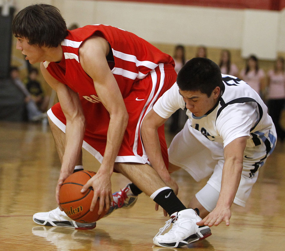 Cheyenne East's Cameron Jaure, right, hits the floor after trying to steal the ball from Central's Kyler Robinson during a game on Saturday, Jan. 22, 2011, at Storey Gym. East won 50-33.