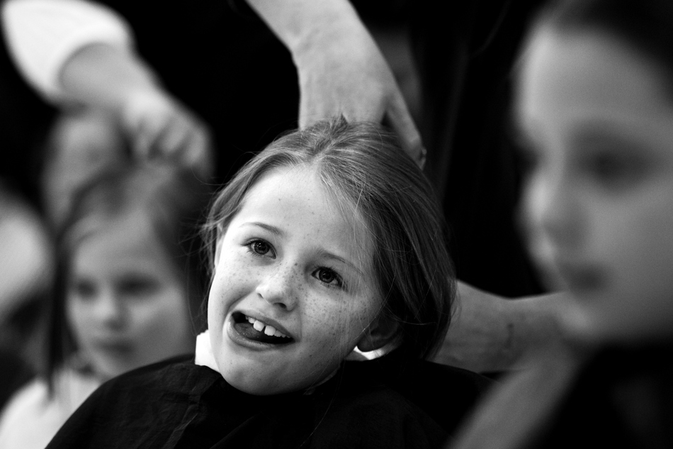 Avery Bott, age 9, reacts as a hair dresser cuts a large lock of her hair off during a student assembly on Friday, Jan. 28, 2011, at Sunrise Elementary. Three students from the school donated their hair to the charity in honor of second grade teacher Heather Blakely-Voyles who has taken a leave of absence from teaching as she battles cancer.