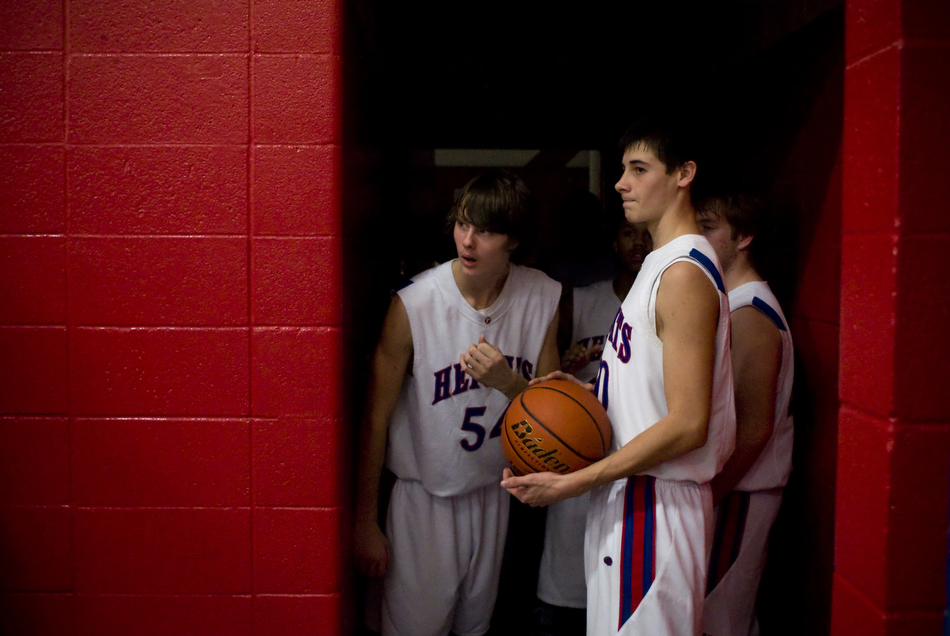 Peoria Heights' Zach Wilson (54) peeks out at the court as teammate Jon Lowry, right, holds the ball ready to lead the team out of the locker room before a game against Beardstown on Friday, Dec. 3, 2010, in Peoria Heights, Ill. Peoria Heights won 67-63.