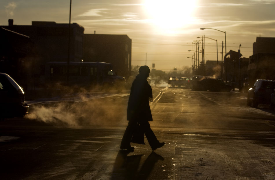 A woman crosses an intersection amid a sea of steam from car exhausts on Tuesday, Feb. 1, 2011, in downtown Cheyenne.