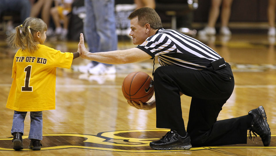 A NCAA official gives a high five to a youngster serving as an honorary tip off kid before a game between Wyoming and BYU on Wednesday, Feb. 2, 2011, in Laramie, Wyo.