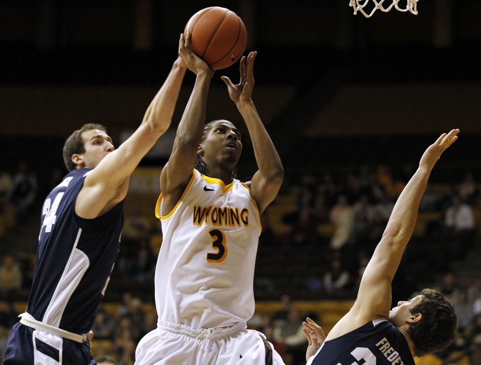 Wyoming guard Desmar Jackson (3) puts up a shot in front of BYU forward  Noah Hartsock (34) and BYU guard Jimmer Fredette, right, during a game on Tuesday, Feb. 2, 2011, in Laramie, Wyo.