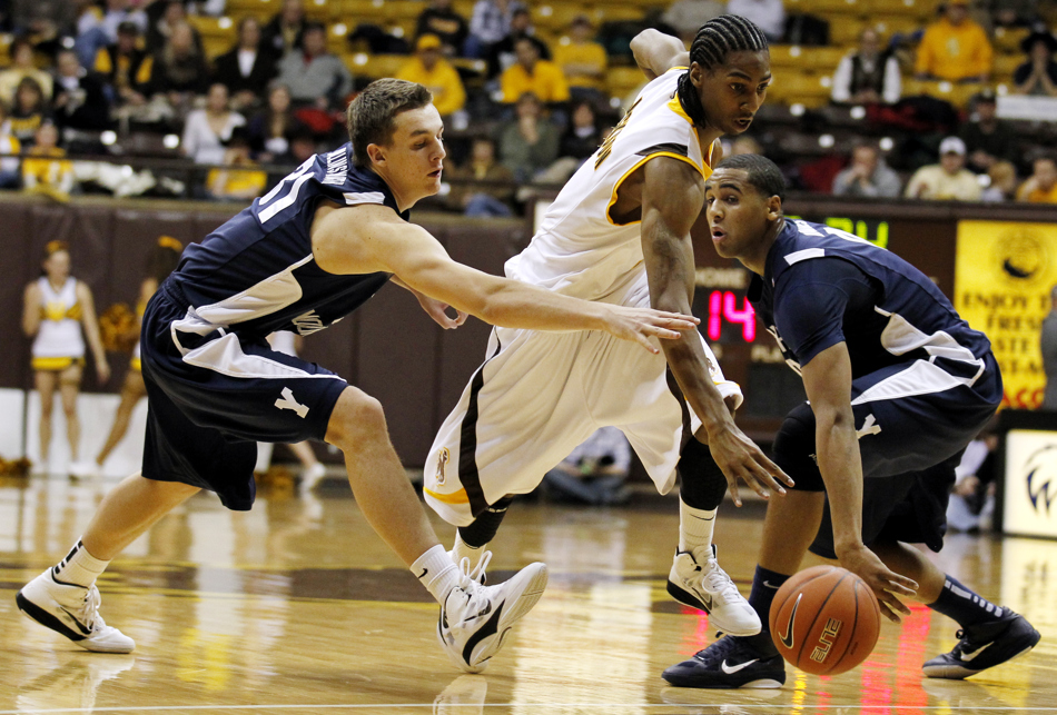 Wyoming guard Desmar Jackson (3) dribbles past BYU guard Kyle Collinsworth (31) and forward Brandon Davies, right, during a game on Tuesday, Feb. 2, 2011, in Laramie, Wyo. BYU won 69-62.