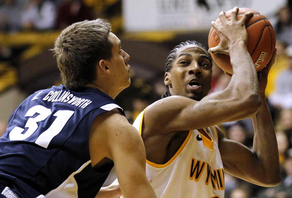 Wyoming guard Desmar Jackson, right, reacts as he's guarded by BYU guard Kyle Collinsworth (31) during a game on Tuesday, Feb. 2, 2011, in Laramie, Wyo. BYU won 69-62.
