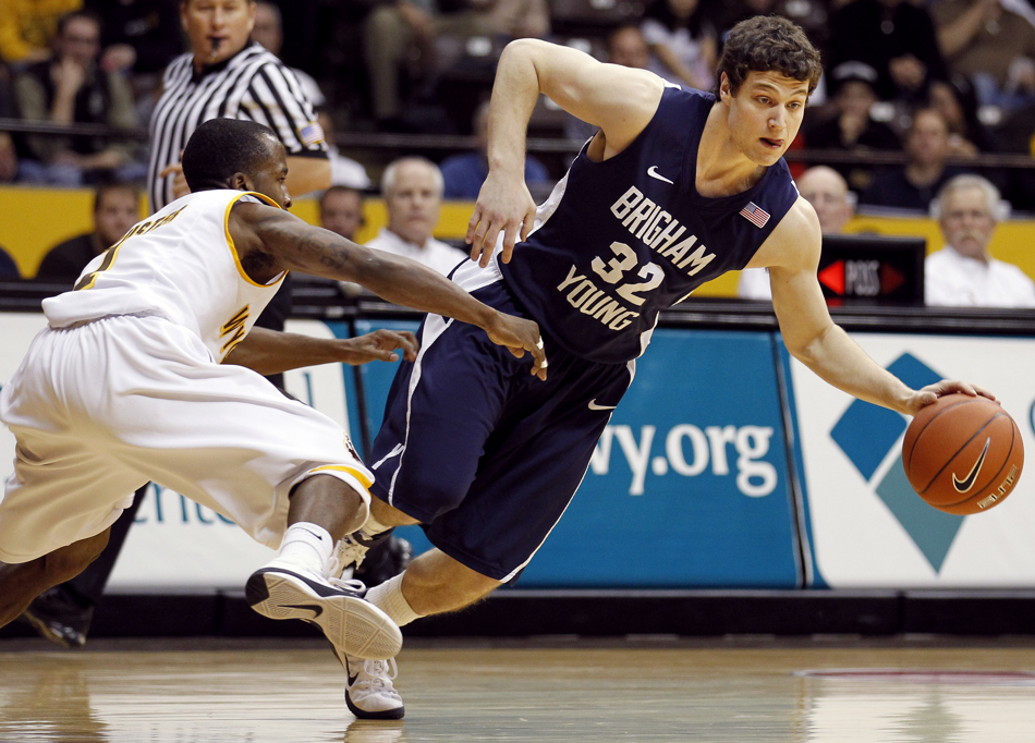 BYU guard Jimmer Fredette (32) drives down the floor and changes directions in front of Wyoming guard JayDee Luster (1) during a game on Tuesday, Feb. 2, 2011, in Laramie, Wyo. BYU won 69-62.