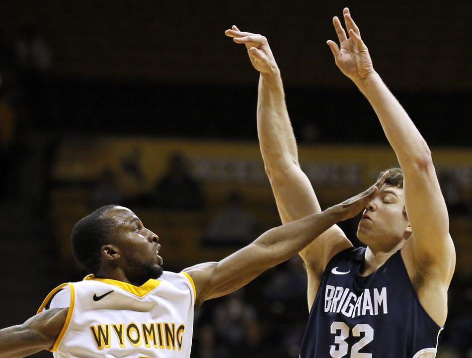 Wyoming guard JayDee Luster, left, hits BYU guard Jimmer Fredette (32) in the face as Fredette follows through on a three pointer during a game on Tuesday, Feb. 2, 2011, in Laramie, Wyo. BYU won 69-62.