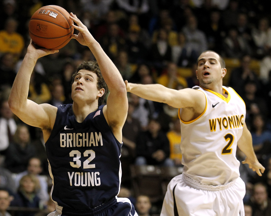 Wyoming guard Arthur Bouedo (2) tries to block a shot from BYU guard Jimmer Fredette (32) during a game on Tuesday, Feb. 2, 2011, in Laramie, Wyo. BYU won 69-62.