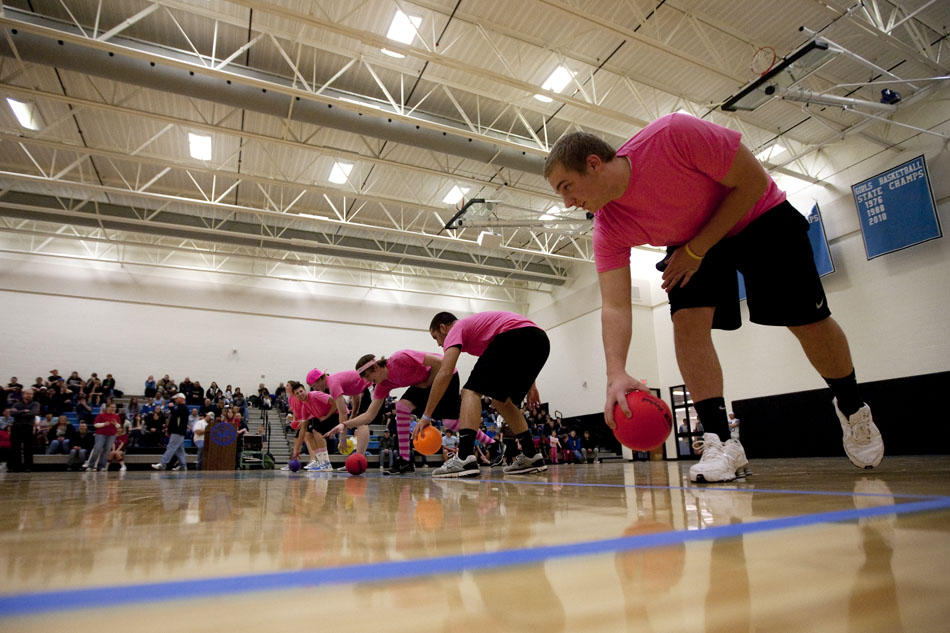Six and the Pink players pick up dodgeballs to start a game during a charity tournament on Tuesday, Feb. 8, 2011, at East High School. The tournament benefited the Denver Children's Miracle Network.