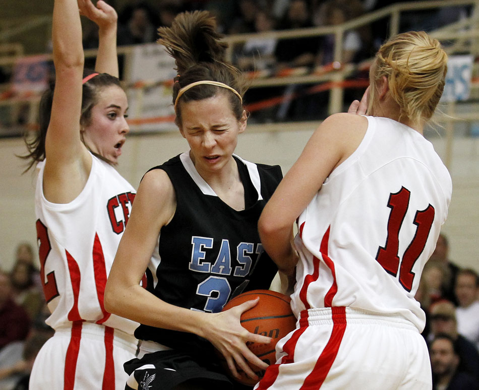 East's Rachel Erickson (31) reacts as she collides with Central's Makena Cameron, left, and Keaton Ross (11) during a game on Saturday, Feb. 12, 2011, at Storey Gym in Cheyenne. Central won 59-51.