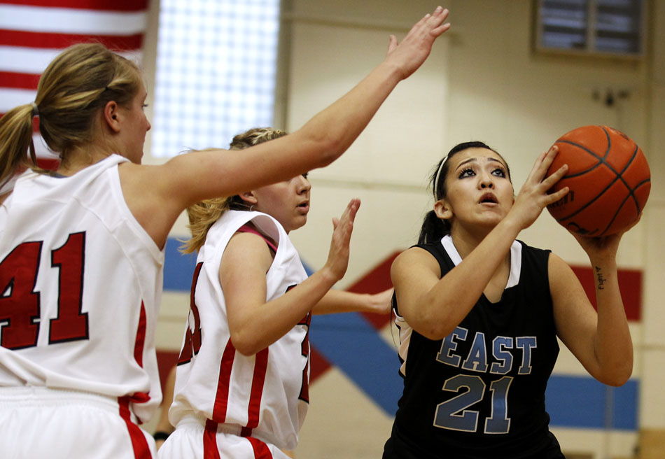 East's Diana Macias (21) puts up a shot in front of Central's Christie Schiel (41) and Cassidy Ayala, center, during a game on Saturday, Feb. 12, 2011, at Storey Gym in Cheyenne. Central won 59-51.