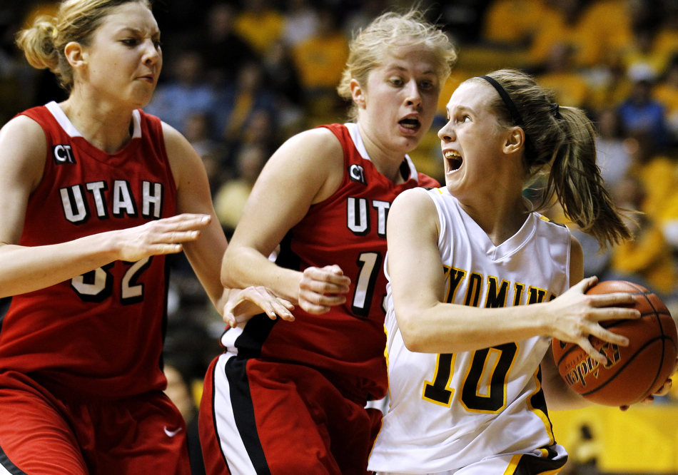 Wyoming guard Bec Campigli (10) looks to pass in front of Utah guard Rachel Messer, middle, and Utah forward Diana Rolniak (32) during a game on Wednesday, Feb. 16, 2011, in Laramie, Wyo.