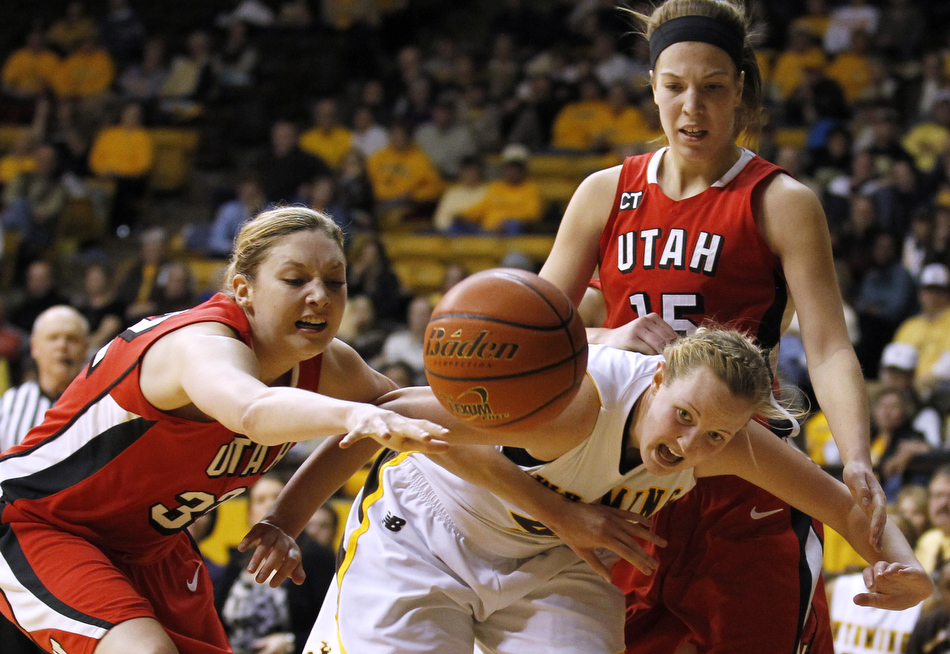 Wyoming forward Hillary Carlson, middle, watches as the ball is batted away from her in front of Utah forwards Diana Rolniak, left, and Michelle Plouffe (15) during a game on Wednesday, Feb. 16, 2011, in Laramie, Wyo.