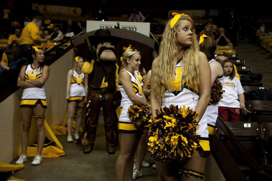 A Wyoming cheerleader watches the video board as she waits for the women's basketball team to run into the stadium before a game against Utah on Wednesday, Feb. 16, 2011, in Laramie, Wyo.