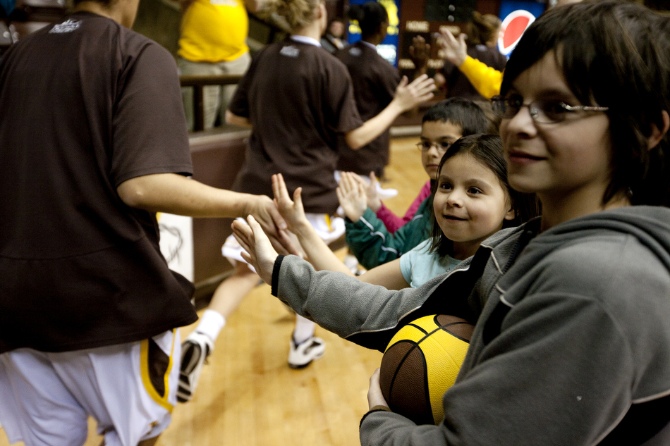Youngsters, including Alayna Rowa, age 6, middle, give high fives to Wyoming basketball players as they run onto the court before a game against Utah on Wednesday, Feb. 16, 2011, in Laramie, Wyo.