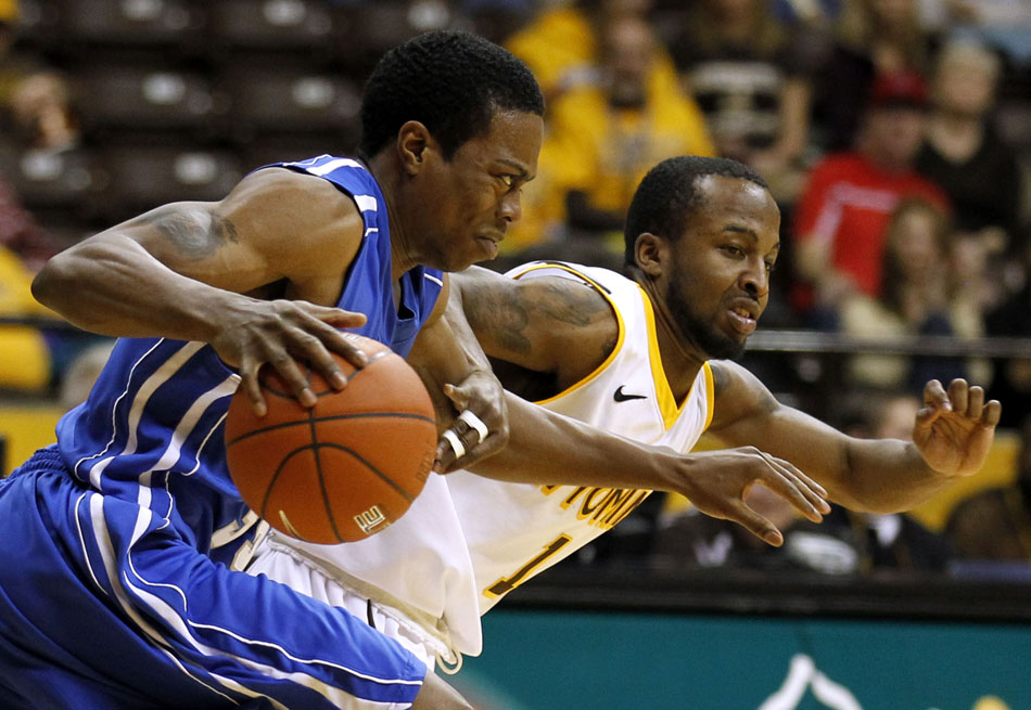 Wyoming guard JayDee Luster (1) tightly guards Air Force guard Evan Washington (35) as Washington takes the ball up the court during a NCAA men's basketball game on Wednesday, Feb. 23, 2011, in Laramie, Wyo.