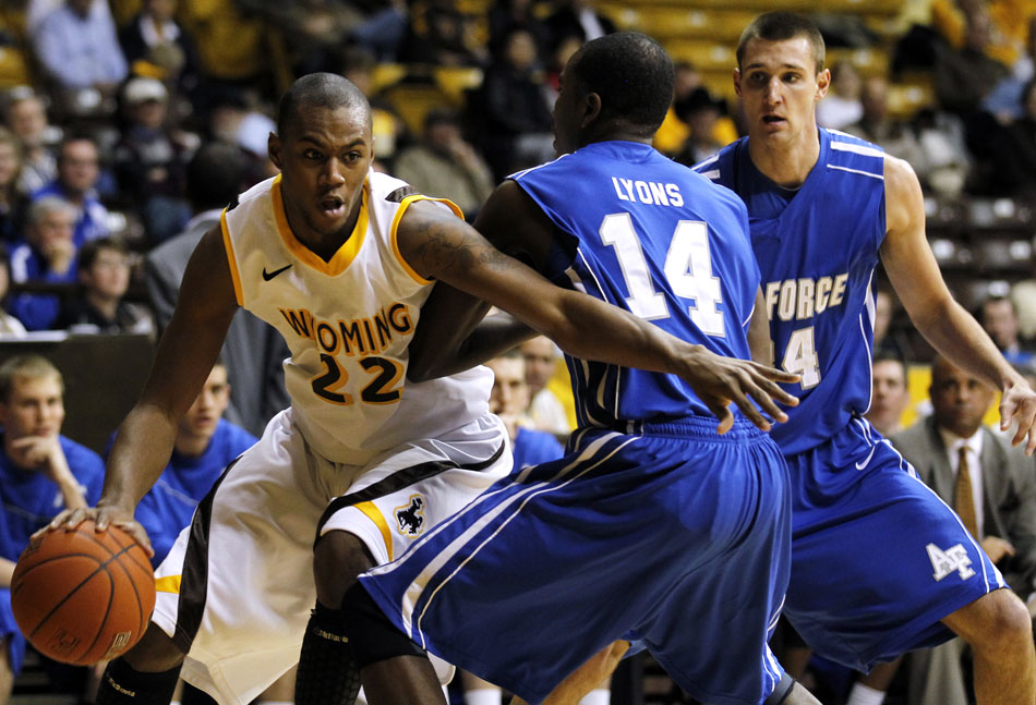 Wyoming forward Amath M'Baye (22) works his way past Air Force guard Michael Lyons (14) and center Taylor Broekhuis (34) during a NCAA men's basketball game on Wednesday, Feb. 23, 2011, in Laramie, Wyo.