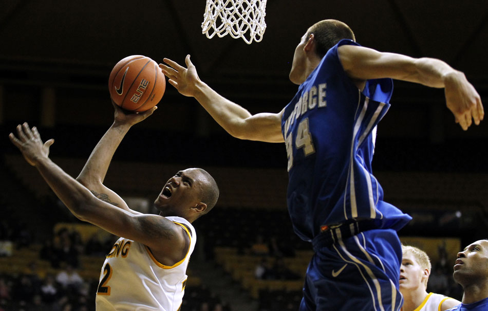 Wyoming forward Amath M'Baye (22) puts up a shot as he's fouled by Air Force center Taylor Broekhuis (34) during a NCAA men's basketball game on Wednesday, Feb. 23, 2011, in Laramie, Wyo.