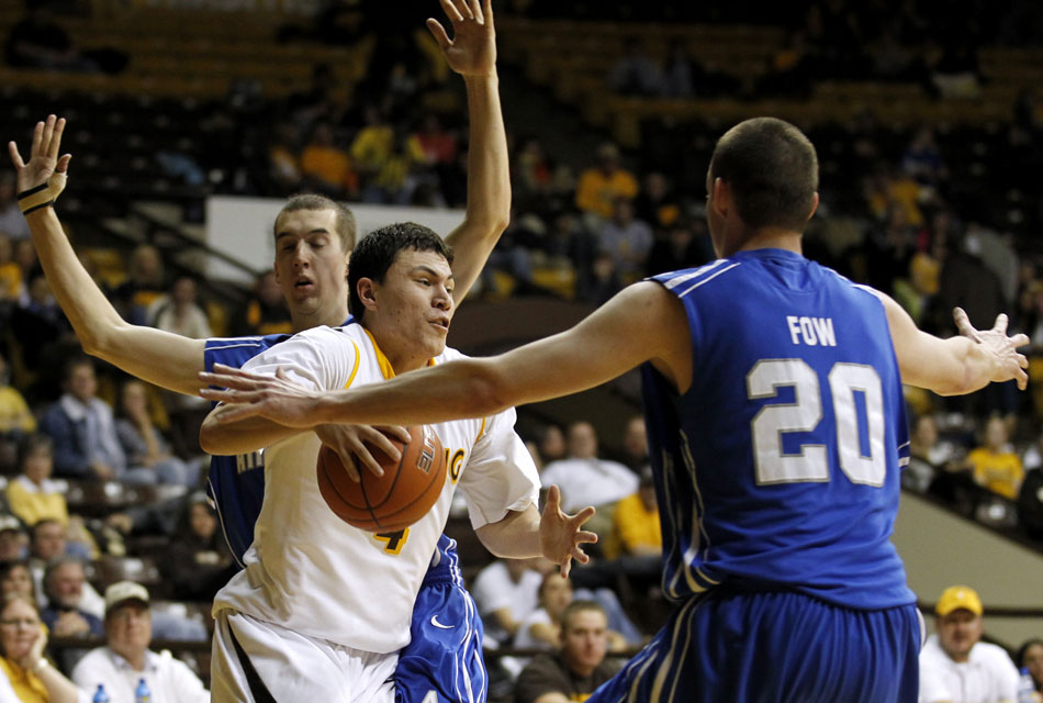 Wyoming guard Francisco Cruz (4) navigates around Air Force forward Tom Fow (20) en route to the basket during a NCAA men's basketball game on Wednesday, Feb. 23, 2011, in Laramie, Wyo.