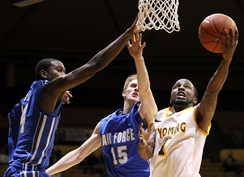 Wyoming guard JayDee Luster (1) puts up a shot in front of Air Force guard/forward Taylor Stewart (15) and guard Michael Lyons (14) during a NCAA men's basketball game on Wednesday, Feb. 23, 2011, in Laramie, Wyo.