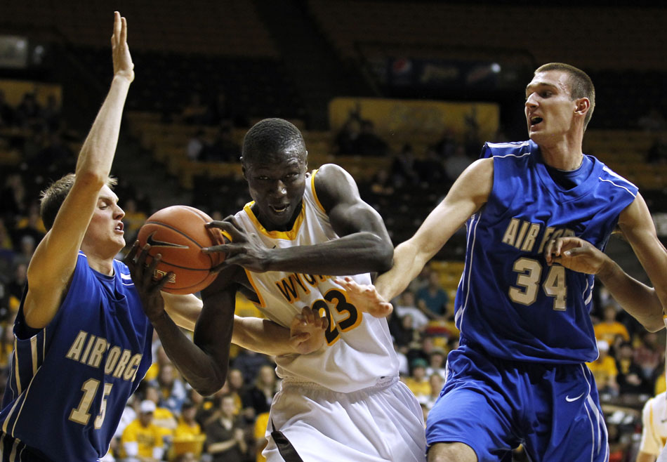 Wyoming forward Djibril Thiam (23) drives into the paint and draws contact from Air Force guard/forward Taylor Stewart (15) and center Taylor Broekhuis (34) during a NCAA men's basketball game on Wednesday, Feb. 23, 2011, in Laramie, Wyo.