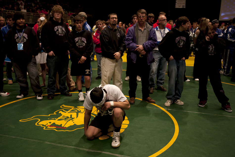 Wright wrestler Juan Rodriguez knees to pray during the March of Champions at the Wyoming wrestling state finals on Friday, Feb. 25, 2011, in Casper, Wyo.