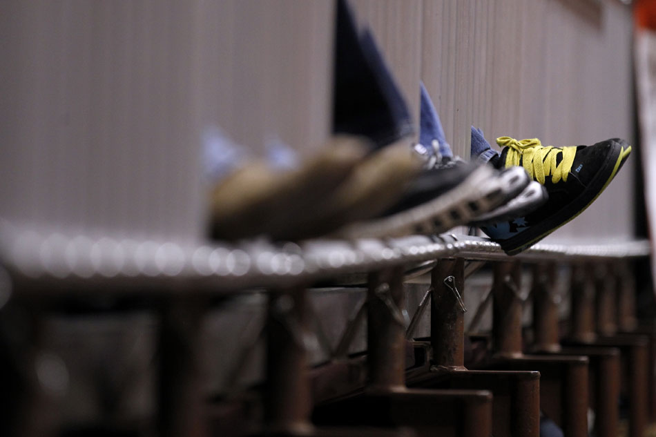 Spectators hang their shoes through a metal barrier as they watch the Wyoming high school state wrestling tournament on Saturday, Feb. 26, 2011, in Casper, Wyo.