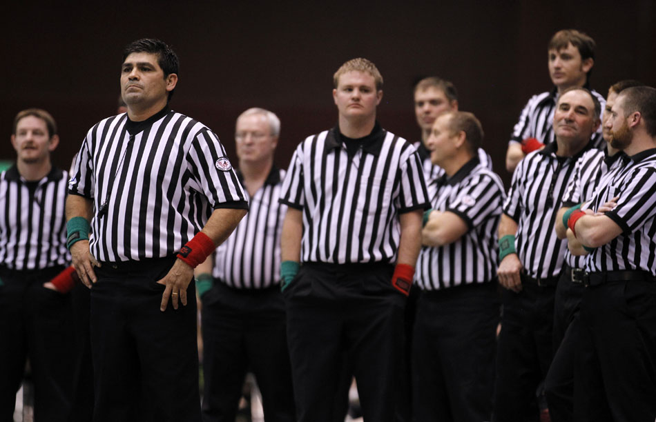 Officials watch as a match at the opposite end of the arena reaches a conclusion during the Wyoming high school state wrestling tournament on Saturday, Feb. 26, 2011, in Casper, Wyo.